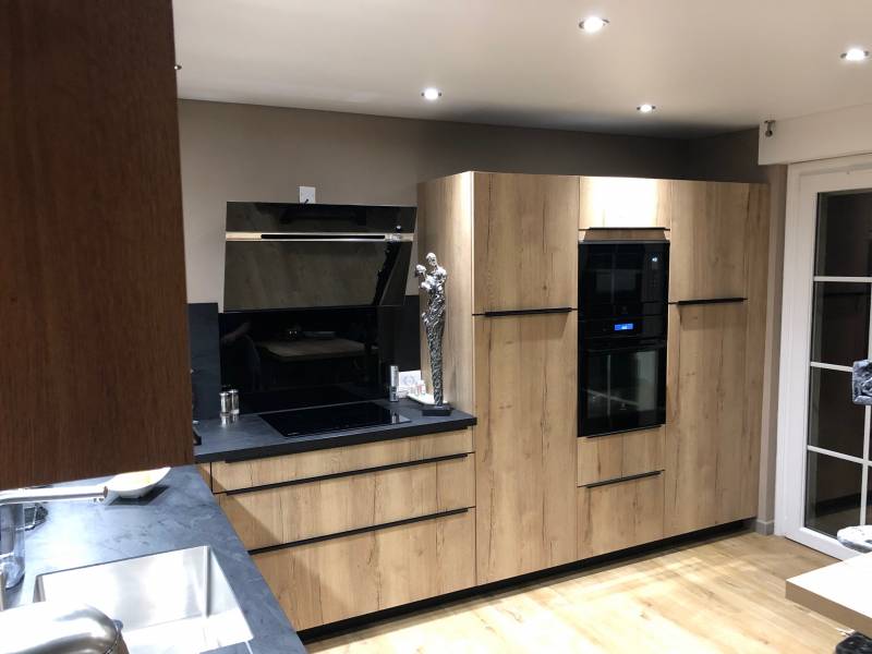 Réalisation d'une cuisine très chic avec façades en bois de chêne à Épreville