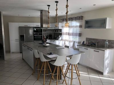 pose d'une cuisine blanche brillante avec îlot central à